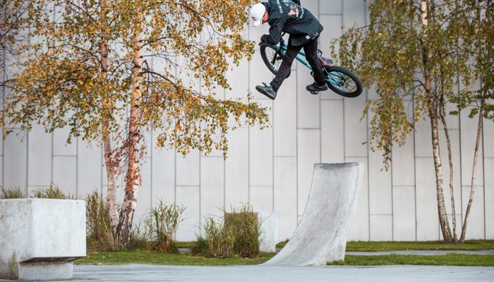 A freestyle cyclist turns in the air after riding up a ramp
