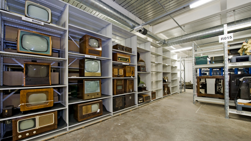 A collection of vintage TVs on shelves in one of the storage rooms at GMRC
